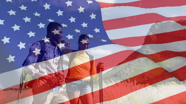 Animation of american flag over diverse couple walking in mountains