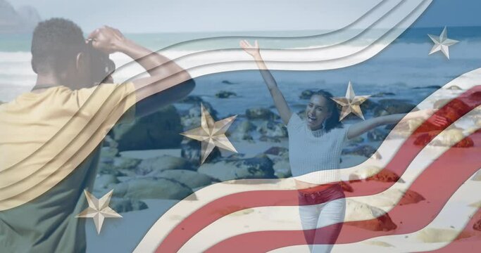 Animation of american flag over african american couple taking photo at beach