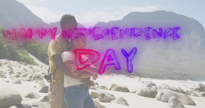 Animation of text independence day over african american couple embracing at beach