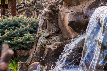 Rocky terrain with a waterfall and a pond. Russia.