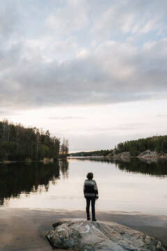 Utforskare st&aring;r p&aring; klippa och tittar ut &ouml;ver sj&ouml;