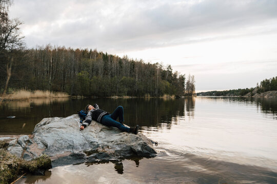 Kvinnlig vandrare vilar p&aring; klippa vid sj&ouml;