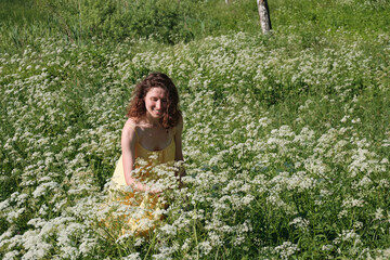 Naklejka na ściany i meble Girl smiles, girl is surrounded by white flowers and birches. Meadow flowers