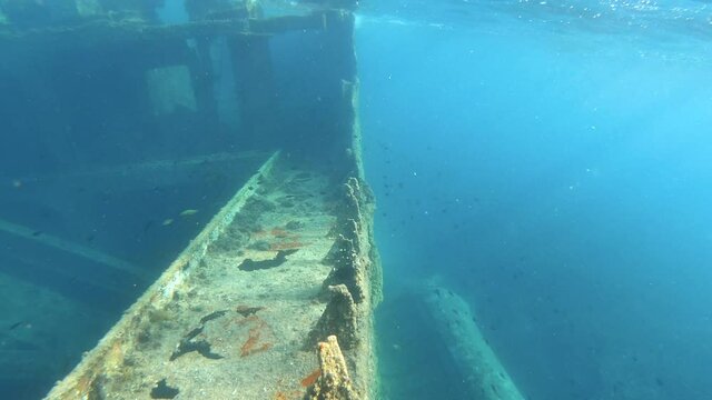 Diver point of view of underwater sunken boat shipwreck. Dreamy light rays and ocean tranquility