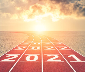 From 2021 into future concept with numbers on running track against sunset desert landscape