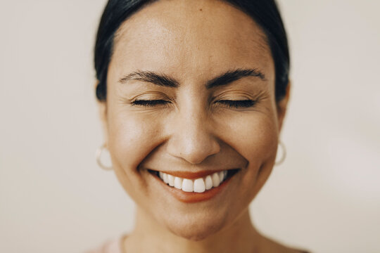 Skrattande kvinna med st&auml;ngda &ouml;gon