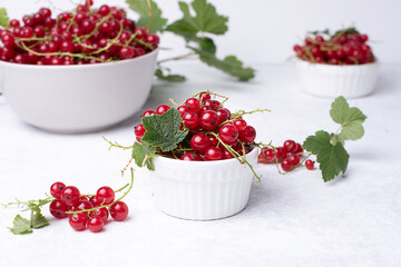 Bowl with ripe red currant berries on a white background, summer berries.