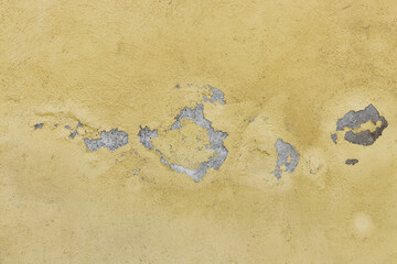 Yellow painted cracked concrete wall