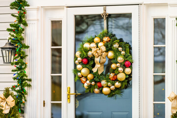 Christmas decoration wreath on door closeup on single family residential suburbs house in northern Virginia with glass windows and golden balls - Powered by Adobe