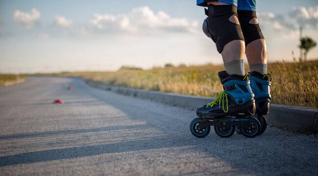 Roller skates. Inline skating on asphalt road in nature, Rollerblader and slalom cone