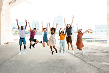 Happy multiracial people jumping together outdoors - Friendship concept with group of young friends from diverse cultures and races having fun with city background - Powered by Adobe