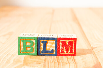 Spectacular wooden cubes with the word BLM BLACK LIVES MATTER on a wooden surface.