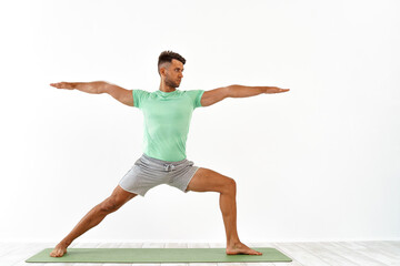 Young handsome man doing yoga isolated on white background