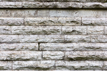 Old stone wall made of gray tiles. Rough surface texture