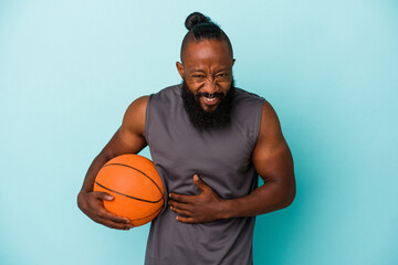 African american man playing basketball isolated on blue background laughing and having fun.