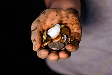 close up of soiled hand holding coins. concept of labourer.