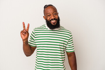 Naklejka premium African american man with beard isolated on pink background joyful and carefree showing a peace symbol with fingers.