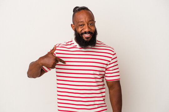 African american man with beard isolated on pink background person pointing by hand to a shirt copy space, proud and confident