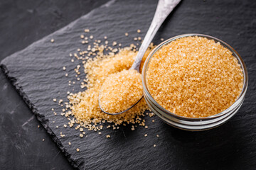 cane brown sugar on a dark stone background
