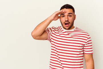 Young caucasian man isolated on white background shouts loud, keeps eyes opened and hands tense.