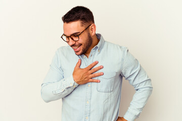 Young caucasian man isolated on white background laughing keeping hands on heart, concept of happiness.