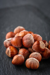 fresh natural hazelnuts on a dark stone background