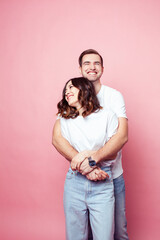 Fototapeta premium young cheerful caucasian couple together having fun on pink background, guy ang girl modern relationship, lifestyle people concept