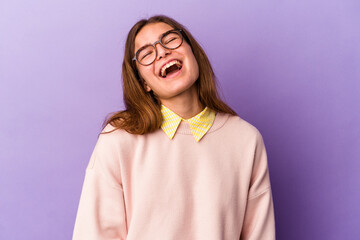 Young caucasian woman isolated on purple background relaxed and happy laughing, neck stretched showing teeth.