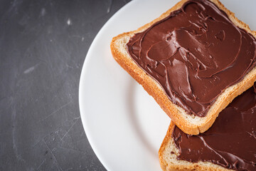 toasts with chocolate butter on a dark stone background