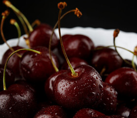 Ripe cherries background. Ripe juicy cherries on a white plate.