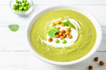 Green pea split soup on wooden background. Copy space.