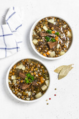 Vegetable beef green lentil soup in bowls. Space for text, flat lay, top view.