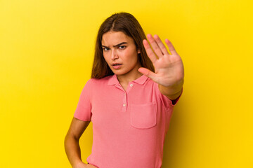 Young caucasian woman isolated on yellow background being shocked due to an imminent danger