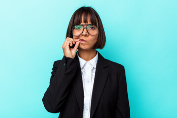 Young business mixed race woman isolated on blue background with fingers on lips keeping a secret.