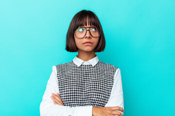 Young mixed race woman isolated on blue background dreaming of achieving goals and purposes