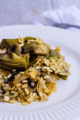 Close up view of rice paella with vegetables on wooden table
