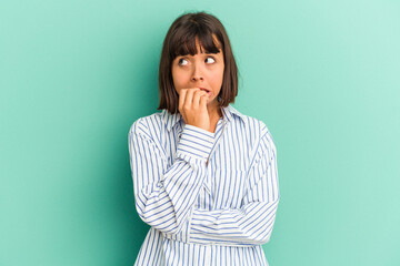 Young mixed race woman isolated on blue biting fingernails, nervous and very anxious.