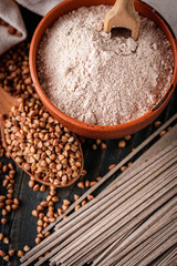 fresh natural buckwheat flour on a dark wooden rustic background culinary concept