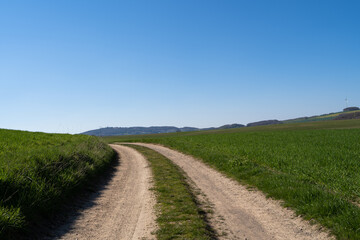 Fototapeta na wymiar Curvy country road on hill with nice blue sky 
