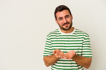 Young caucasian man isolated on white background folding lips and holding palms to send air kiss.