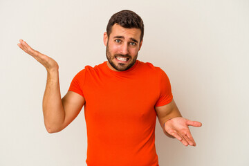 Young caucasian man isolated on white background confused and doubtful shrugging shoulders to hold...