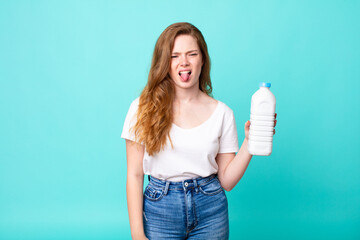 feeling disgusted and irritated and tongue out and holding a milk bottle
