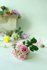 Bouquet of fresh roses, a package with wildflowers on a light background with a place for an inscription, the concept of a romantic congratulation, invitation, wedding, postcard