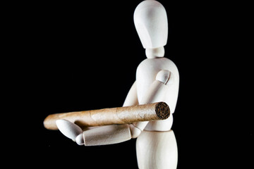 wooden dummy figurine and tobacco cigar cigarette, health concept, puppet made of wood, art mennequin.Wooden Doll