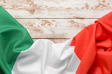 Italian flag on light wooden background, closeup