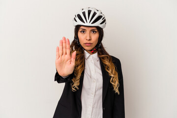 Young mexican woman riding a bicycle to work isolated on white background standing with outstretched hand showing stop sign, preventing you.