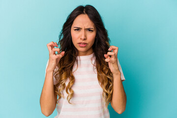 Fototapeta na wymiar Young mexican woman isolated on blue background upset screaming with tense hands.