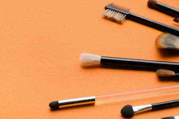 Set of makeup brushes on color background