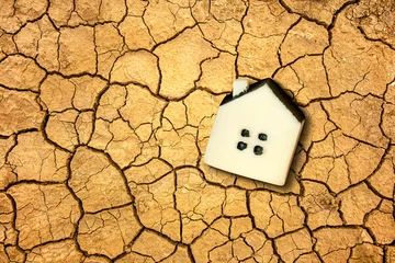 Fototapeten Global warming and climate changing concept with a little toy house on the dried soil. © Dmytro