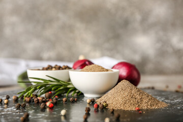 Composition with black pepper powder and peppercorns on grunge background
